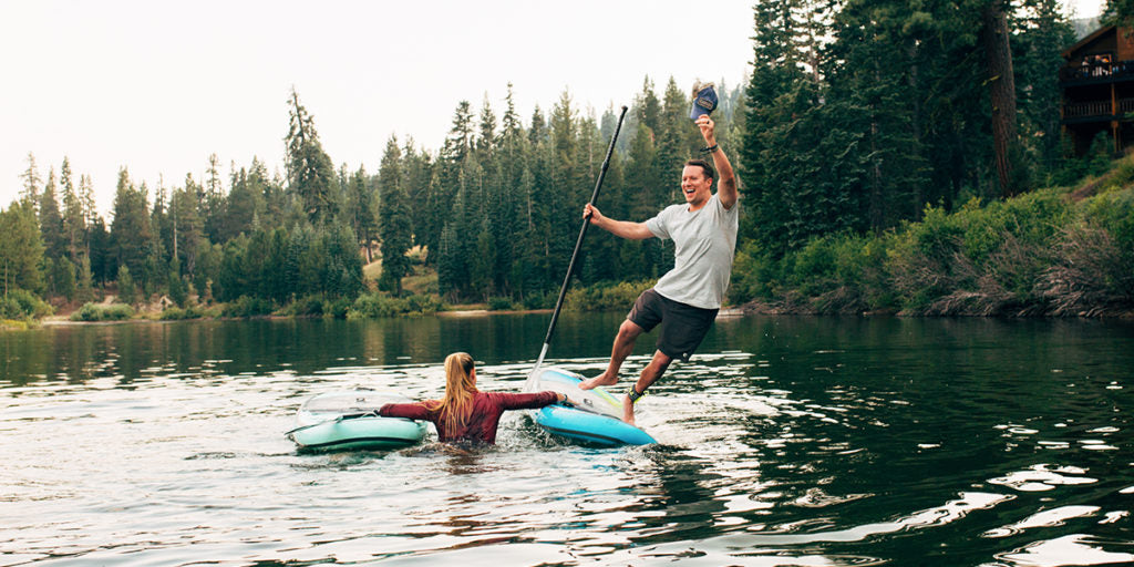 man falling off paddle board