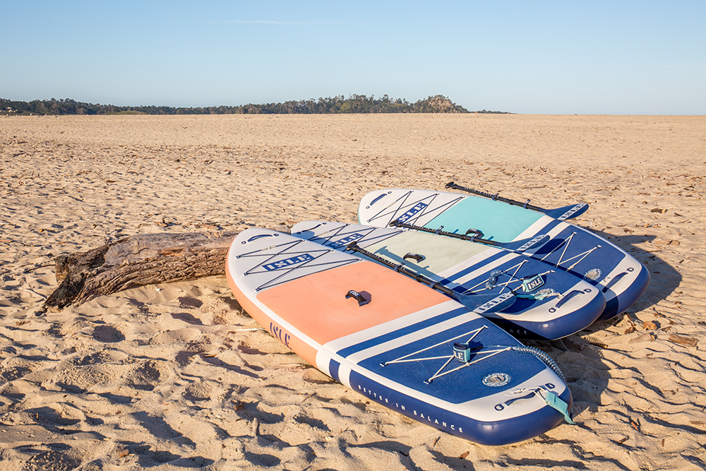 3 SUP boards sitting on sand