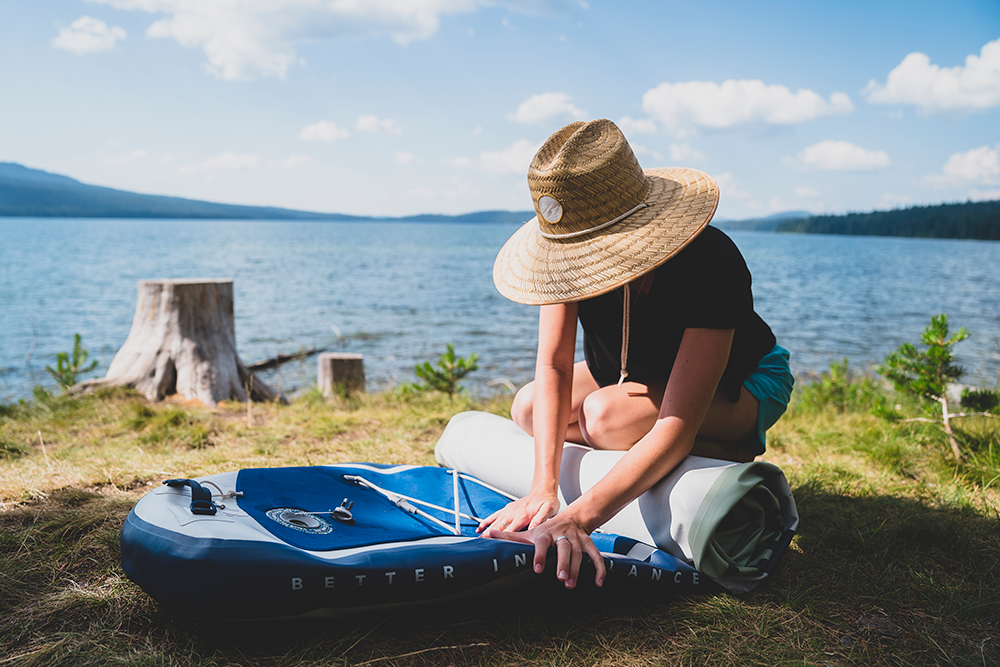 woman rolling up paddle board